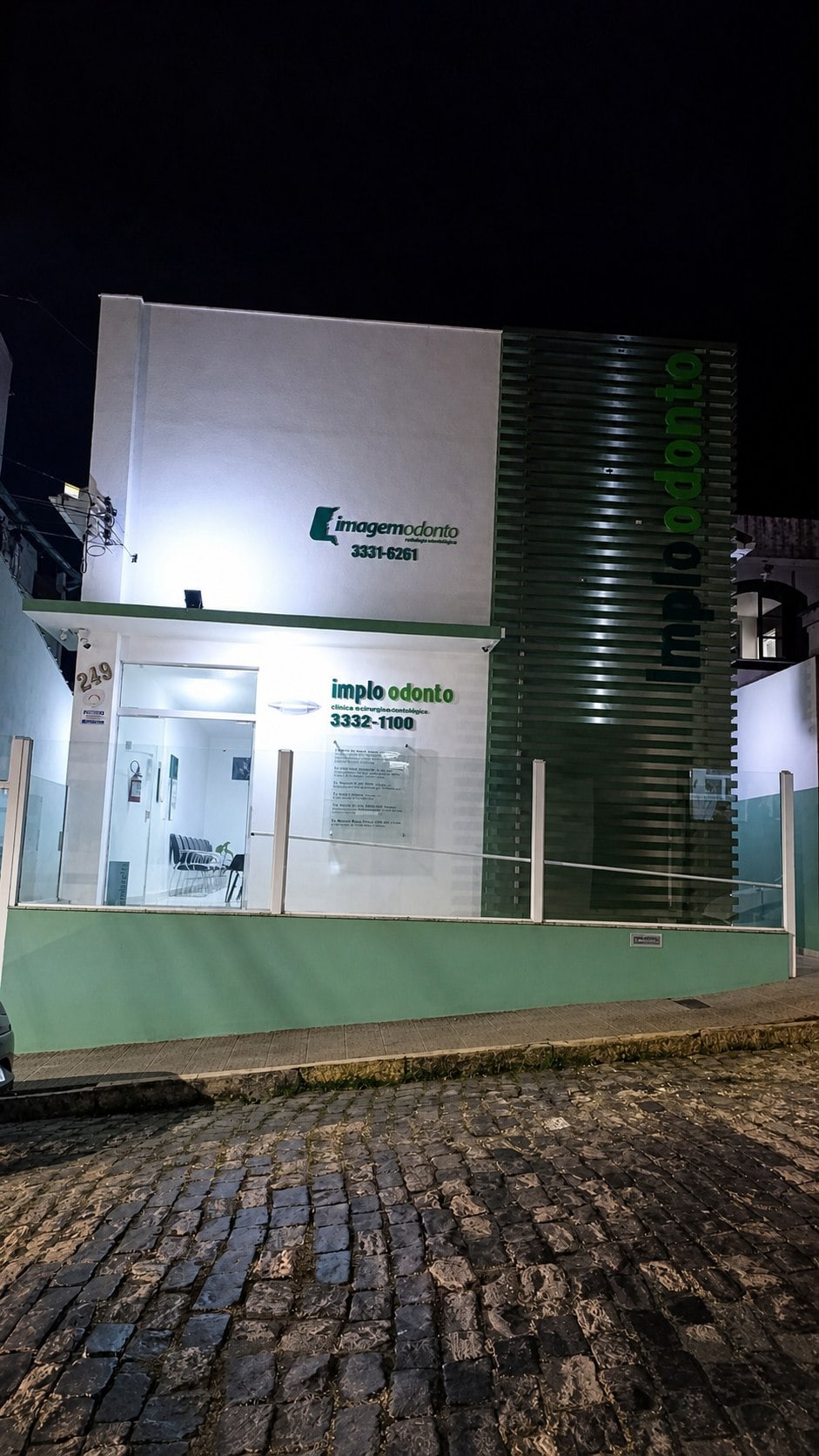 Fachada iluminada da Implo Odonto à noite